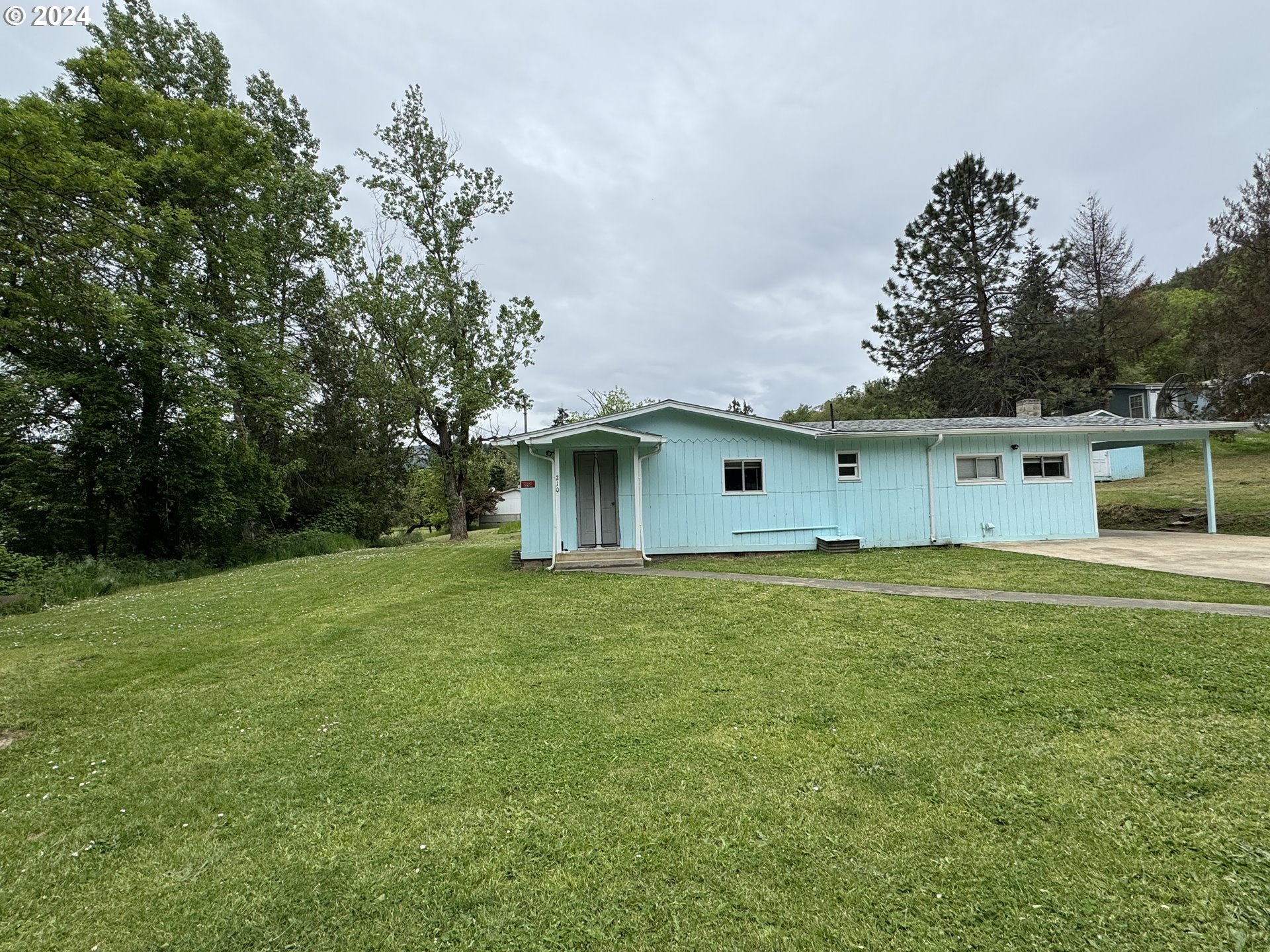 210 Winter Green Drive Riddle, OR 97469 - Photo 2 of 30 a backyard of a house with lots of green space