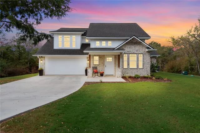 a front view of a house with a yard and trees