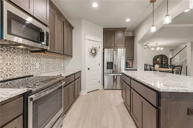 a kitchen with stainless steel appliances granite countertop a sink stove microwave and cabinets
