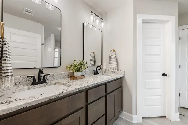 a bathroom with double sink and a mirror