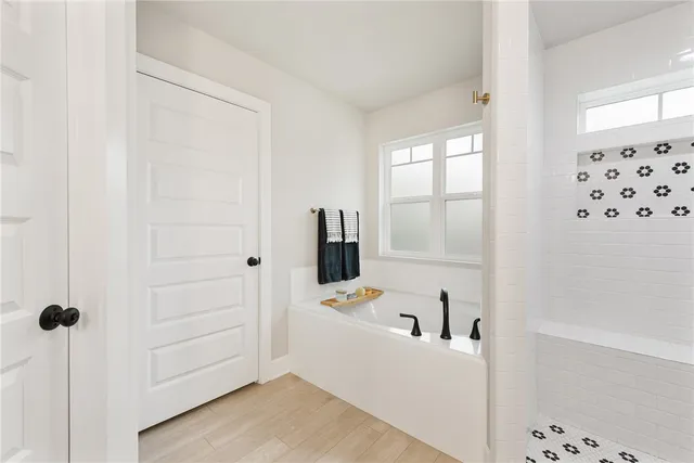 a view of a bedroom with a bed and wooden floor
