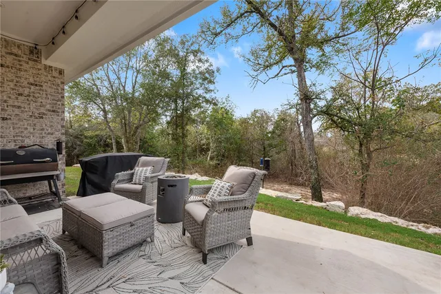 a view of a patio with a table and chairs next to a yard