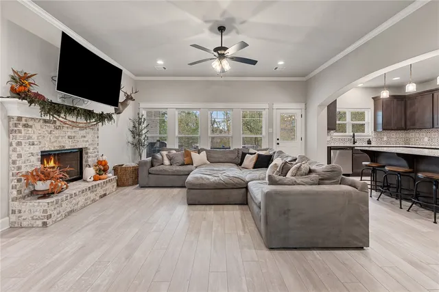 a living room with furniture a fireplace and a flat screen tv