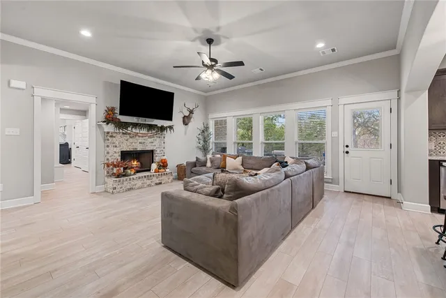 a living room with furniture a flat screen tv and a fireplace