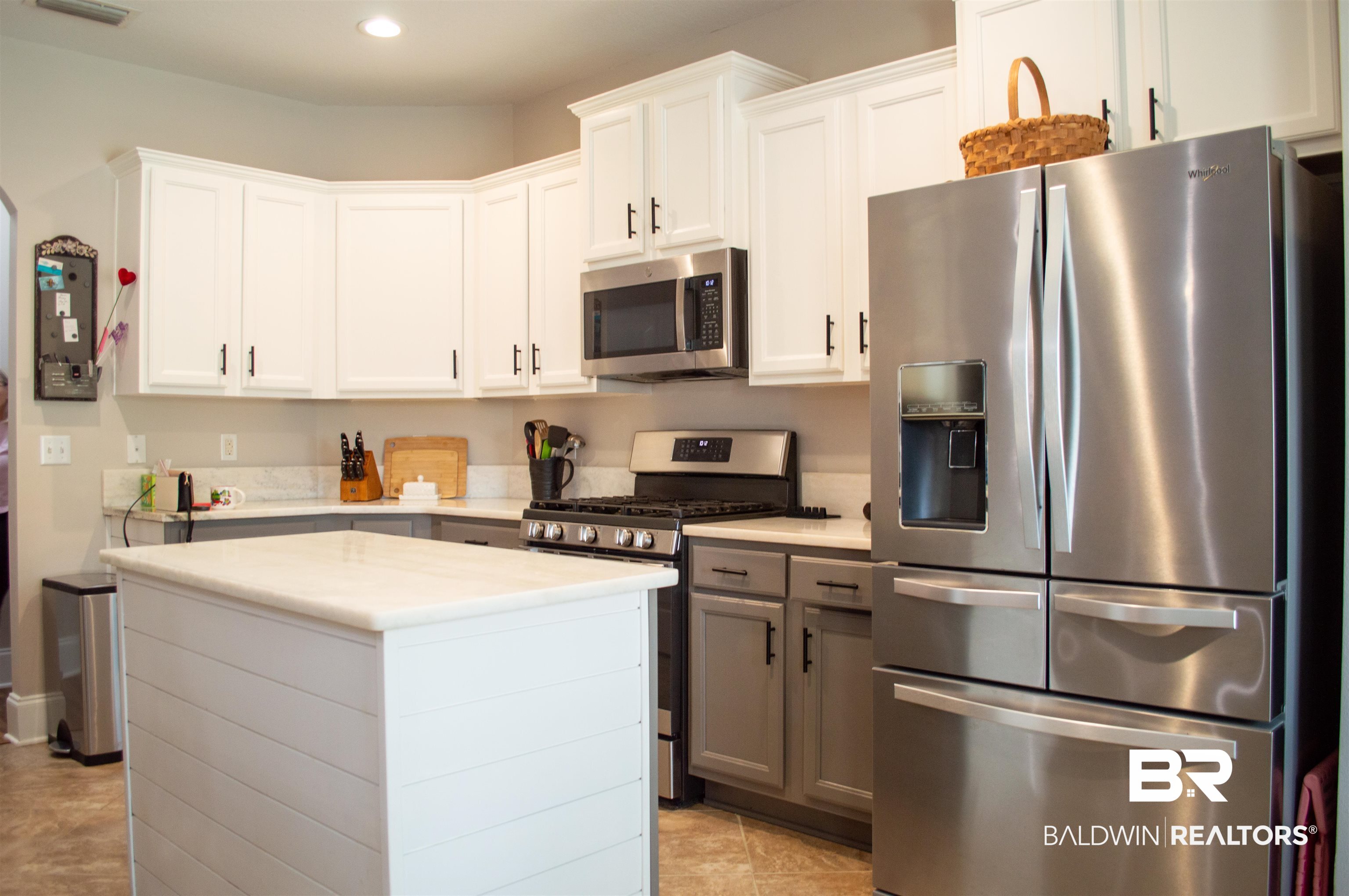 1124 West Orlando Drive Foley, AL 36535 - Photo 15 of 51 Dual tone kitchen featuring stainless steel appliances, two tone cabinets, a center island, recessed lighting, and light stone counters