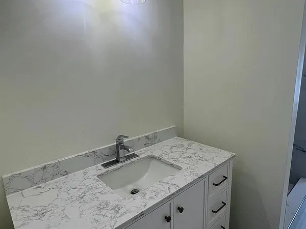 a bathroom with a granite countertop sink and vanity