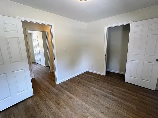 an empty room with wooden floor and closet