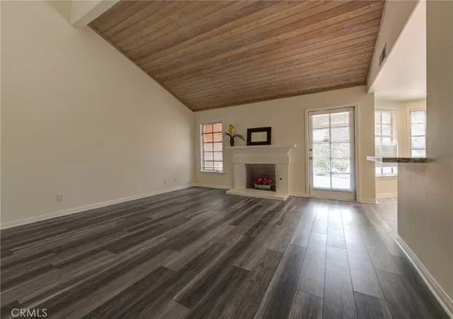 a view of empty room with wooden floor and fireplace