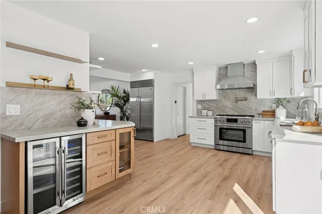 a kitchen with stainless steel appliances a stove top oven and a refrigerator