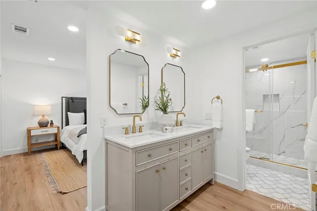 a en suite bathroom with a double vanity sink and a mirror