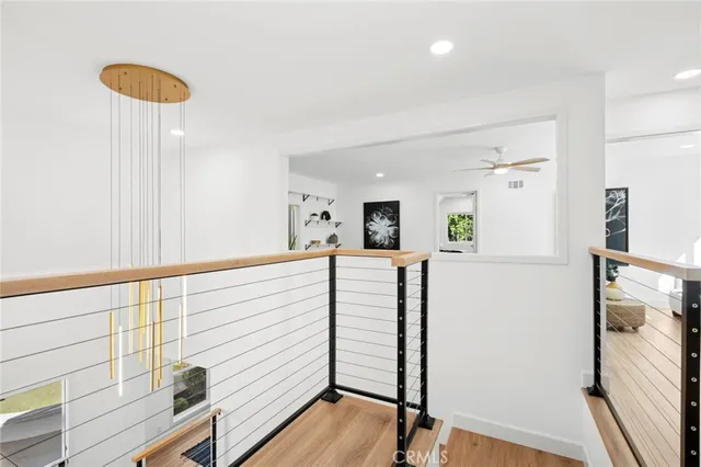 a view of a hallway with furniture and wooden floor