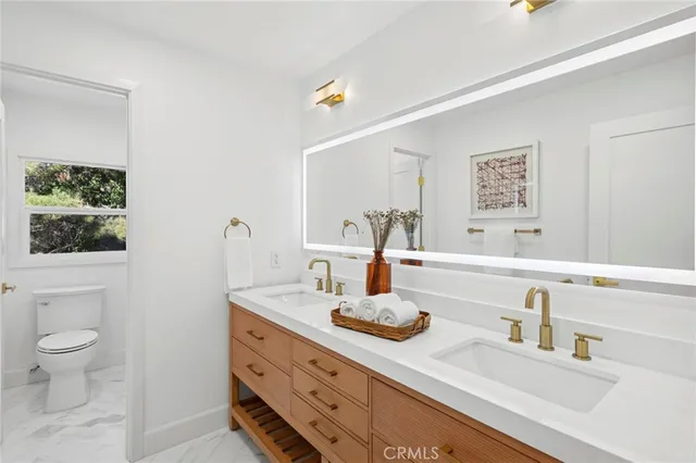 a bathroom with a granite countertop sink mirror vanity and toilet