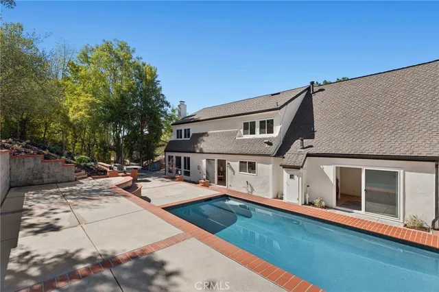 a view of a house with pool and sitting area