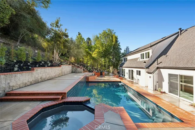 a view of a house with pool and sitting area