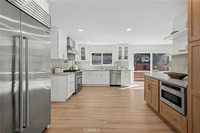 a kitchen with stainless steel appliances a refrigerator and a stove top oven