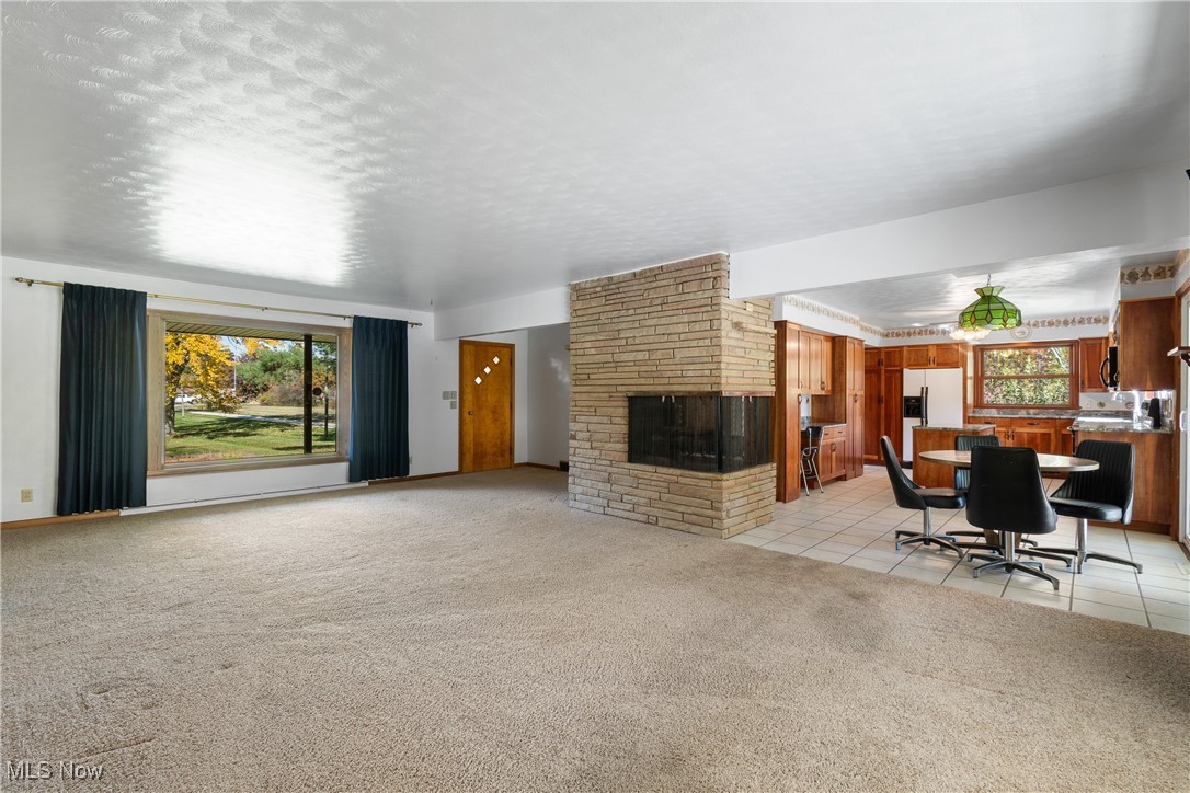 3240 Copley Road Akron, OH 44321 - Photo 7 of 35 Living room with a textured ceiling, a fireplace, and light tile patterned floors