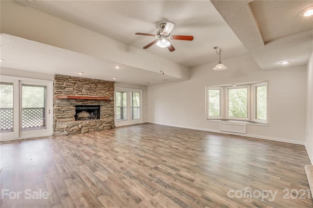 5349 Charlotte Highway Lake Wylie, SC 29710 - Photo 12 of 35 an empty room with wooden floor fireplace and windows