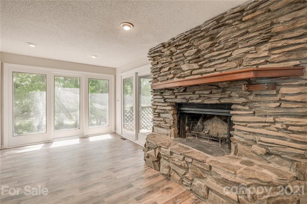 5349 Charlotte Highway Lake Wylie, SC 29710 - Photo 13 of 35 an empty room with wooden floor fireplace and windows