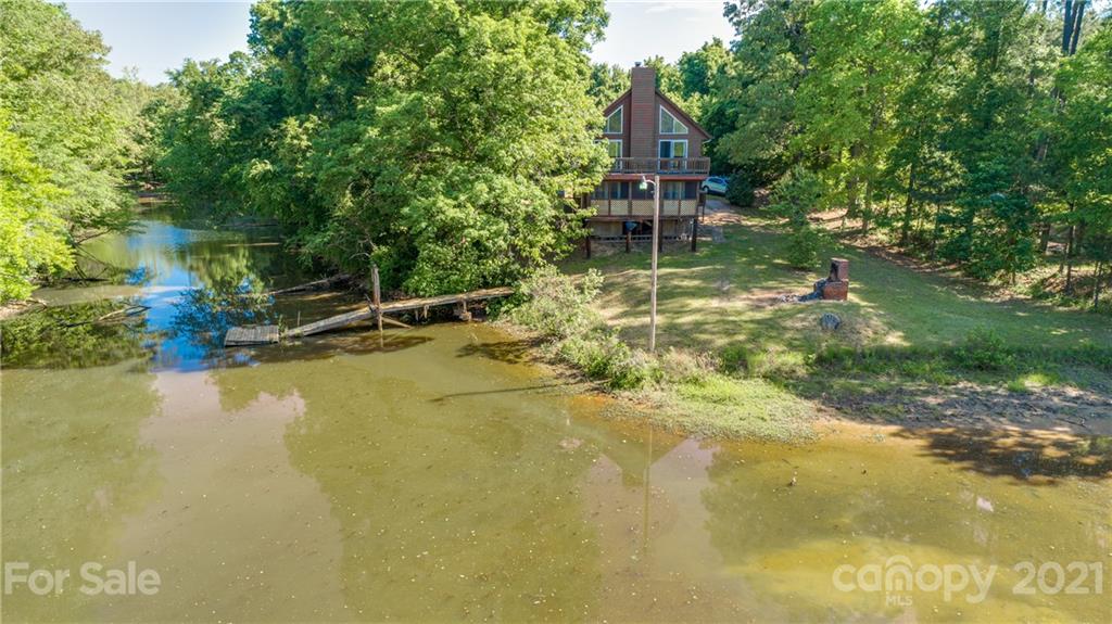 5349 Charlotte Highway Lake Wylie, SC 29710 - Photo 9 of 35 a backyard of a house with table and chairs under an umbrella
