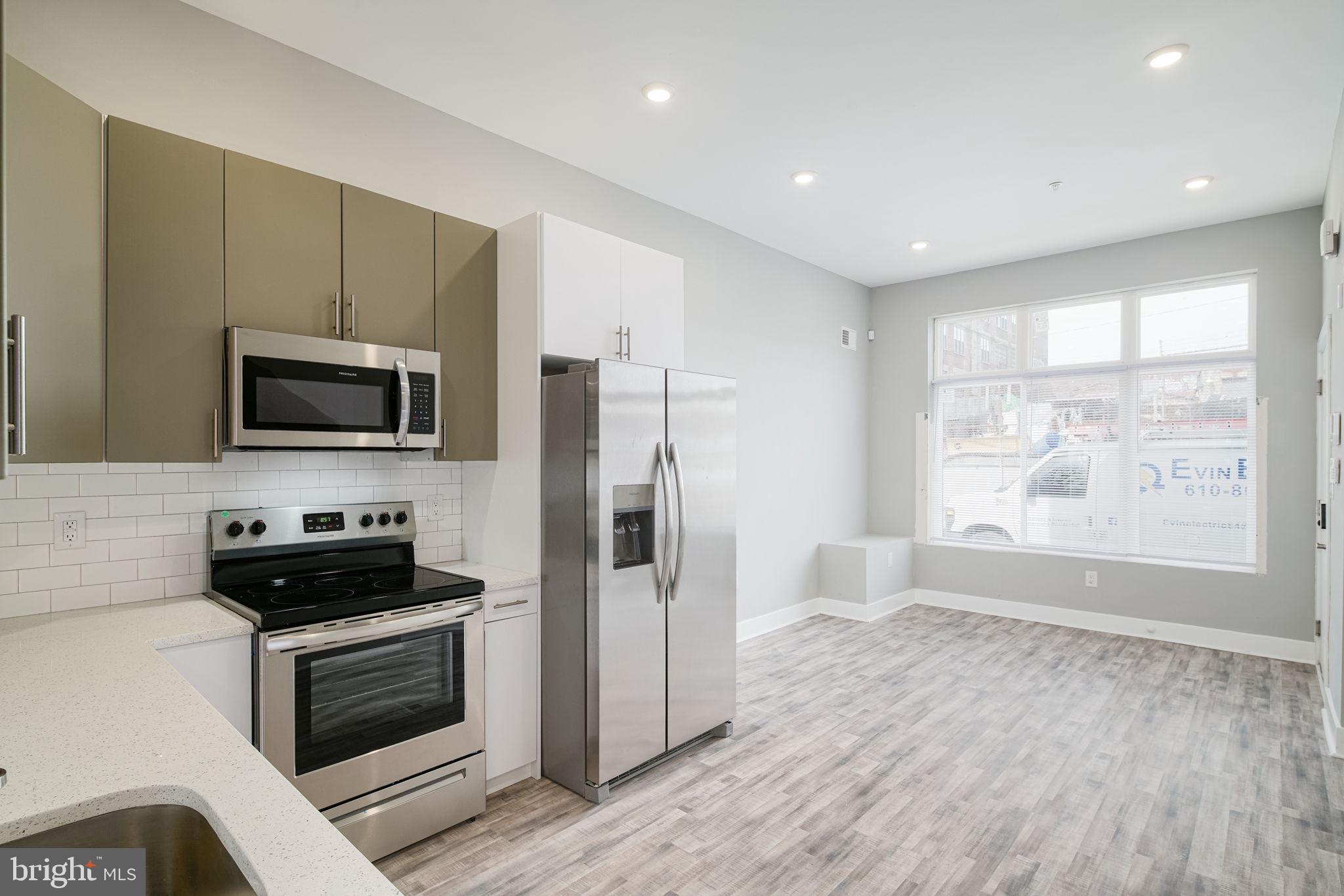 1443 North 8th Street, Unit 2 Philadelphia, PA 19122 - Photo 1 of 18 a kitchen with a refrigerator stove and microwave