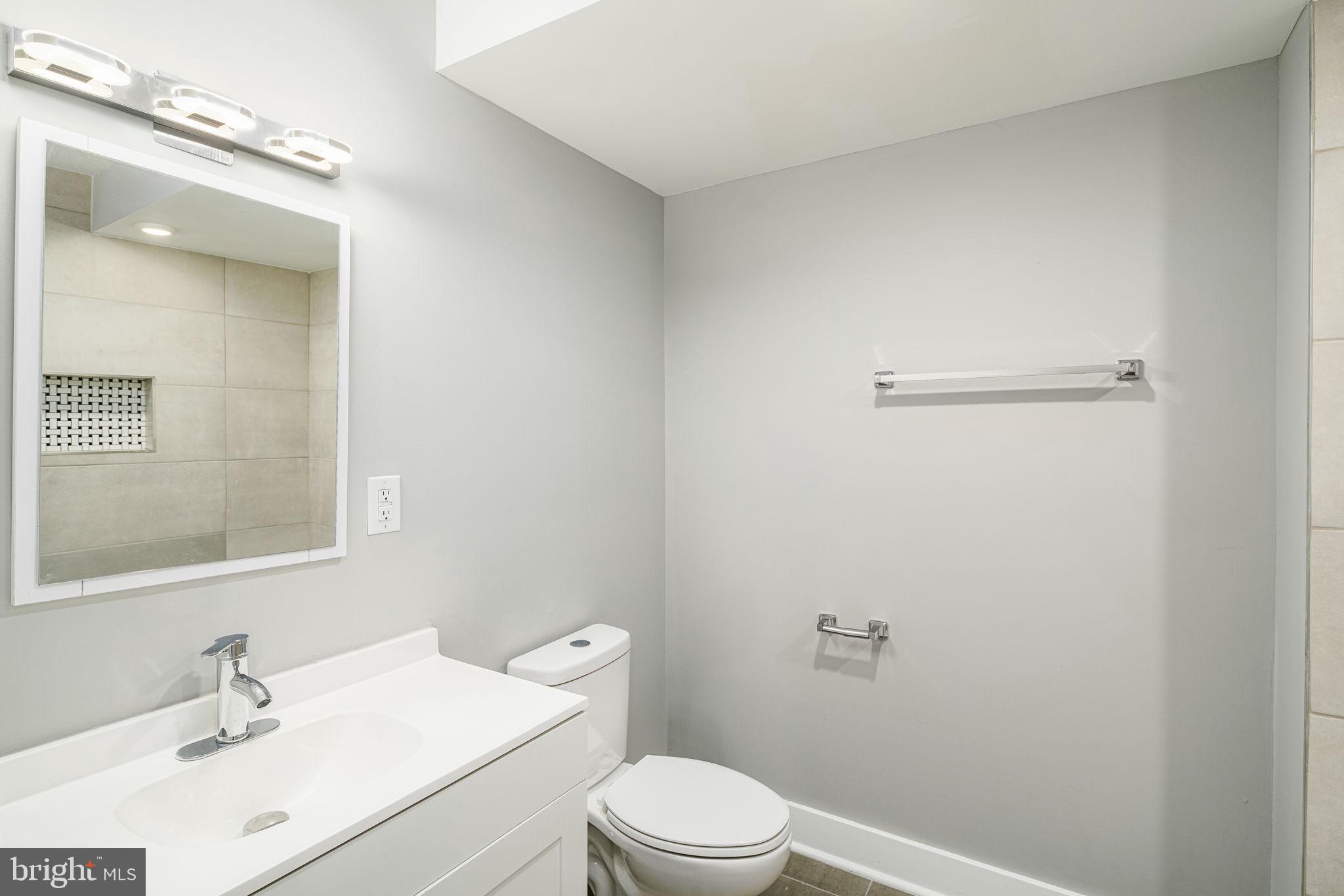 1443 North 8th Street, Unit 2 Philadelphia, PA 19122 - Photo 14 of 18 a bathroom with a sink mirror vanity and toilet