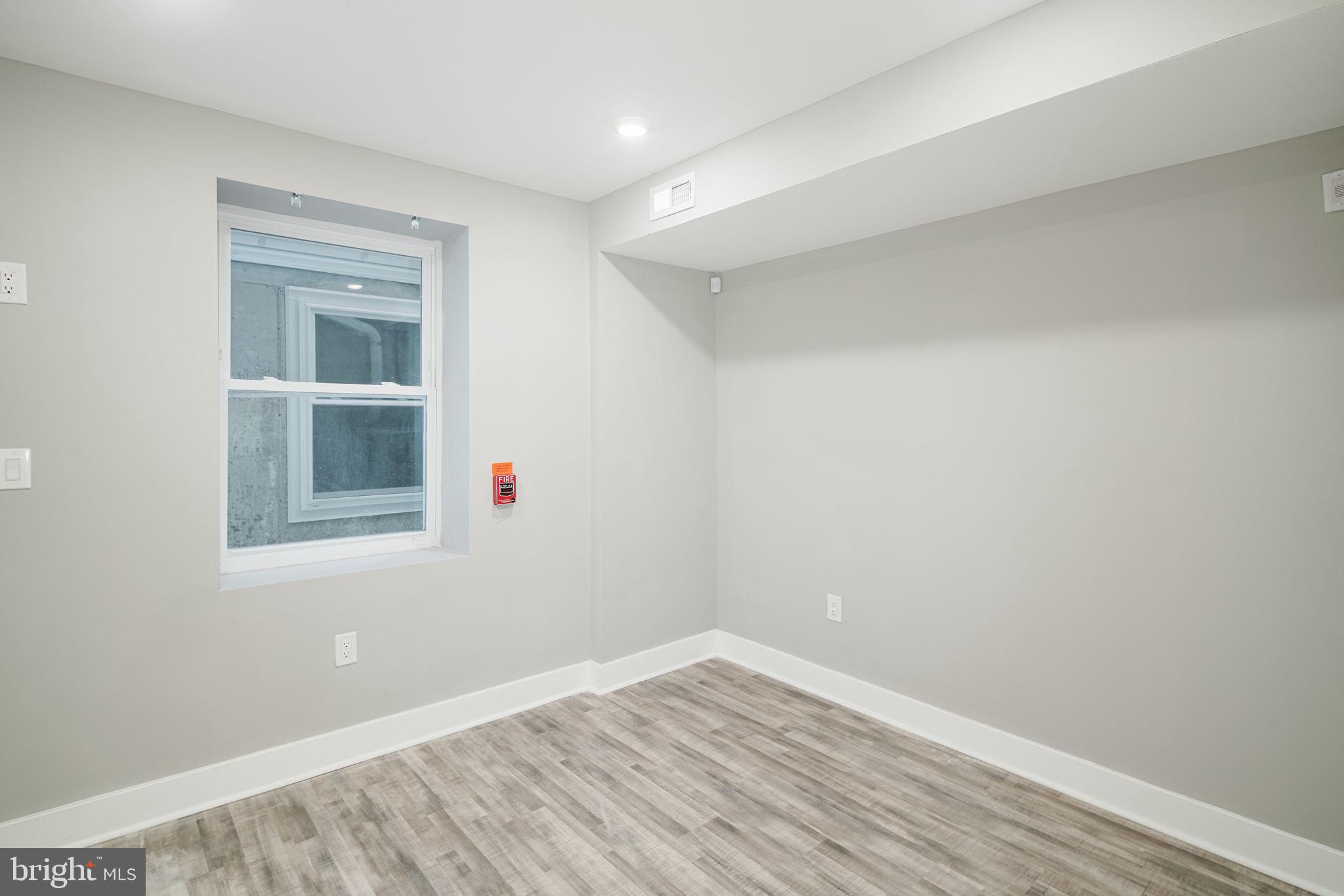 1443 North 8th Street, Unit 2 Philadelphia, PA 19122 - Photo 15 of 18 a view of an empty room with wooden floor and a window