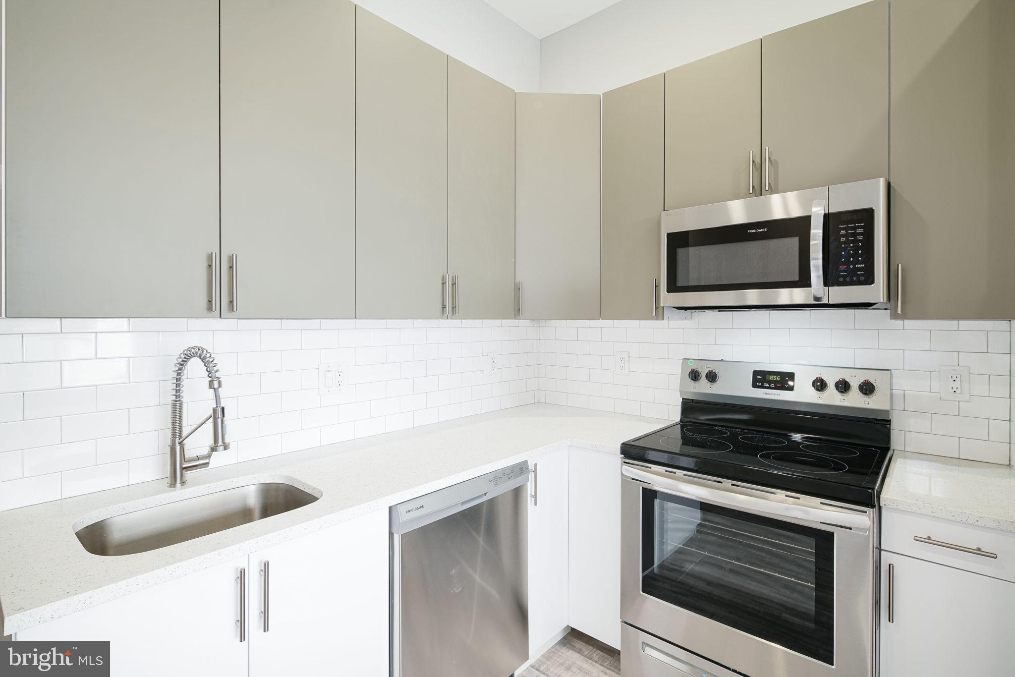 1443 North 8th Street, Unit 2 Philadelphia, PA 19122 - Photo 3 of 18 a kitchen with granite countertop a stove and a sink