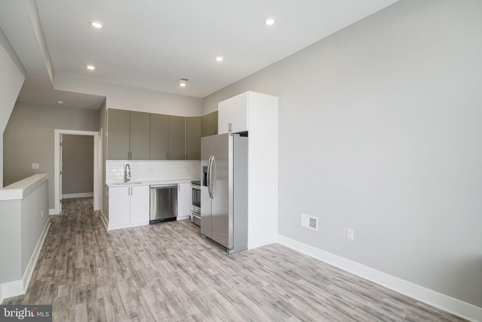 1443 North 8th Street, Unit 2 Philadelphia, PA 19122 - Photo 4 of 18 a view of a kitchen with a sink and a refrigerator