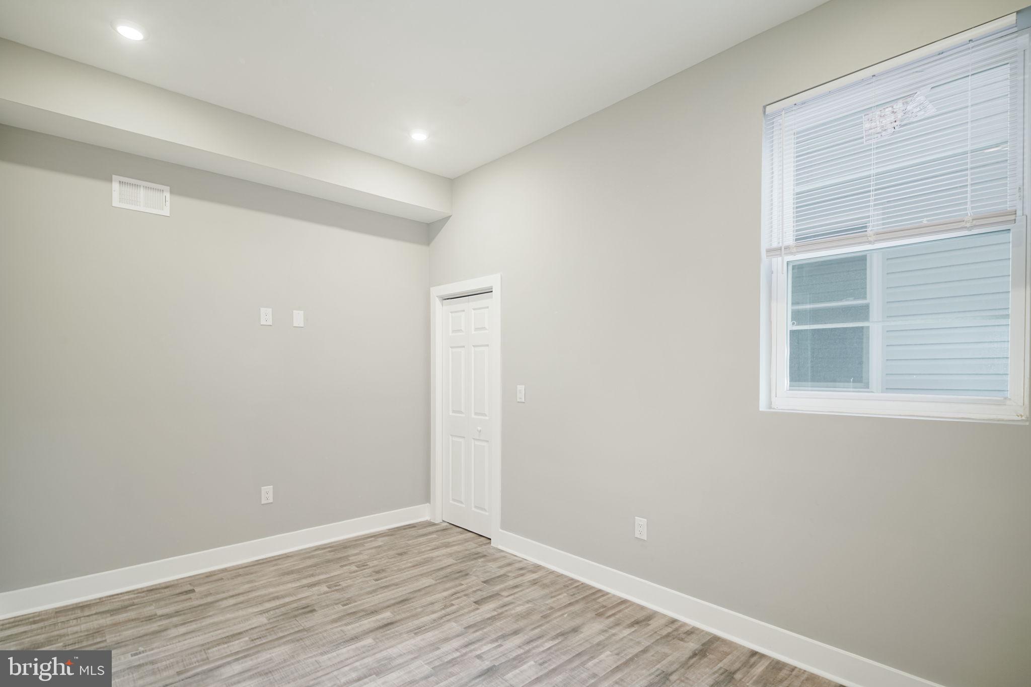 1443 North 8th Street, Unit 2 Philadelphia, PA 19122 - Photo 7 of 18 a view of an empty room with wooden floor and a window