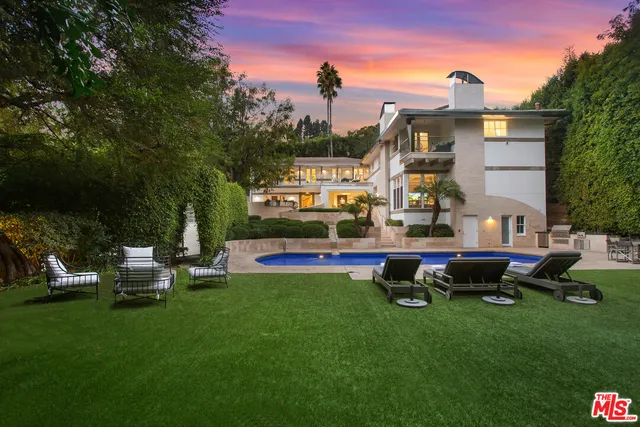 a front view of a house with a garden and sitting area
