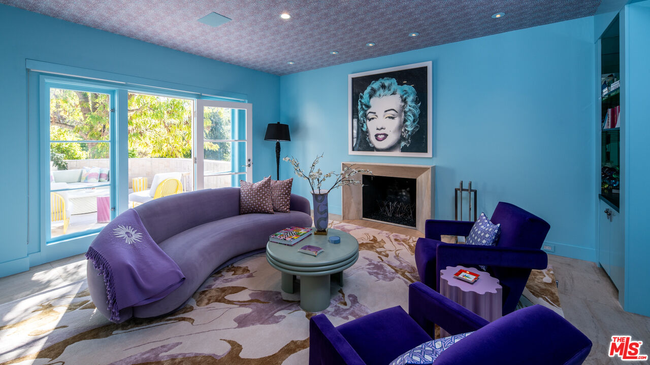 661 Doheny Road Beverly Hills, CA 90210 - Photo 2 of 33 a living room with furniture a fireplace and a large window