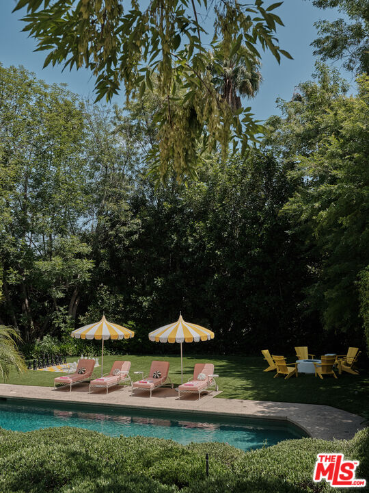 661 Doheny Road Beverly Hills, CA 90210 - Photo 21 of 28 a backyard of a house with table and chairs
