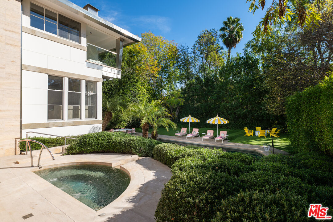 661 Doheny Road Beverly Hills, CA 90210 - Photo 31 of 33 a view of a swimming pool with a garden