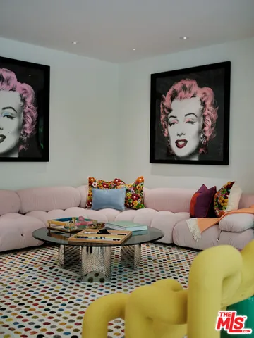 a living room with furniture and wall paintings