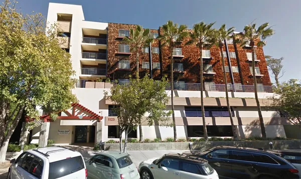 a front view of a building and car parked