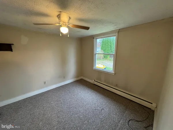 an empty room with a window and ceiling fan