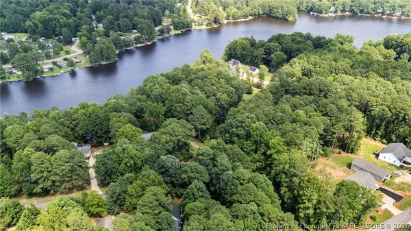 an aerial view of a houses with a yard and lake view