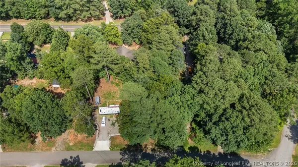 an aerial view of a house with a yard and large trees