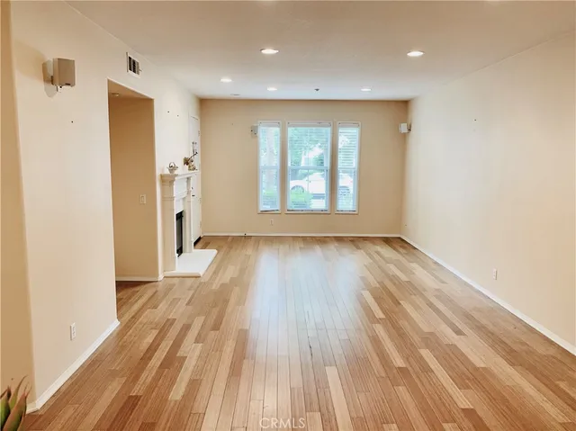 a view of hallway with a large window and wooden floor