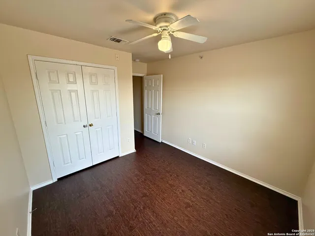 an empty room with a ceiling fan and a window