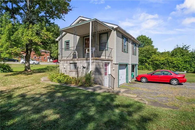 a front view of a house with yard and green space