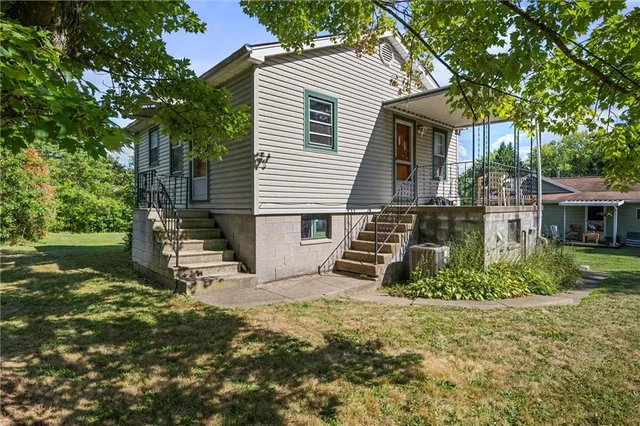 a view of a house with backyard and a tree