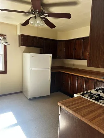 a kitchen with stainless steel appliances granite countertop a refrigerator a sink dishwasher a stove and white cabinets