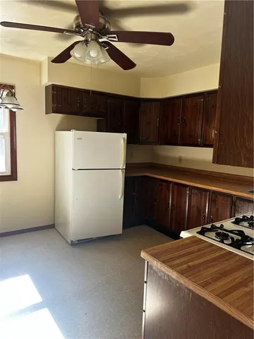 a kitchen with stainless steel appliances granite countertop a refrigerator a sink dishwasher a stove and white cabinets