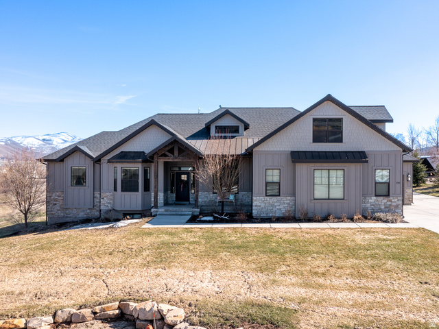 641 West 500 South Midway, UT 84049 - Photo 1 of 52 Modern farmhouse exterior featuring board and batten siding, stone accents, and a covered entry with exposed timber framing