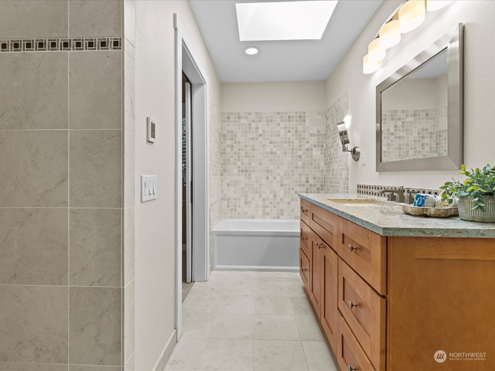 19911 Welch Road Snohomish, WA 98296 - Photo 29 of 40 a bathroom with a granite countertop sink a mirror and a bathtub