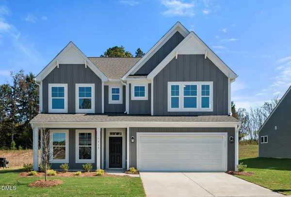 a front view of a house with a garden and yard