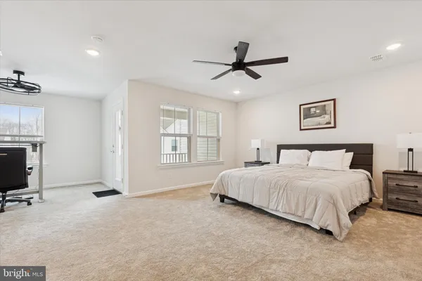 a spacious bedroom with a bed a window and a flat screen television