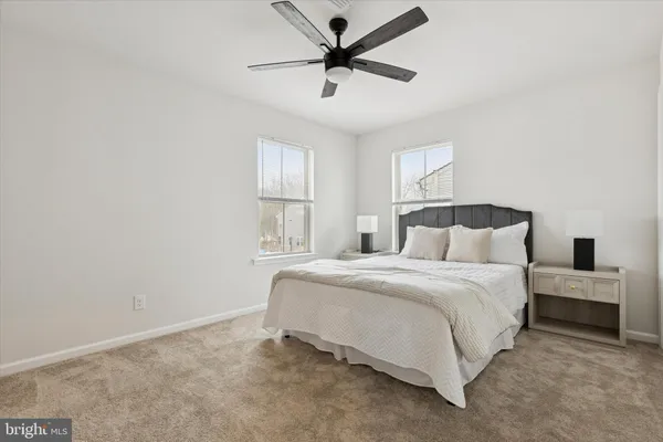 a bedroom with a bed and a ceiling fan