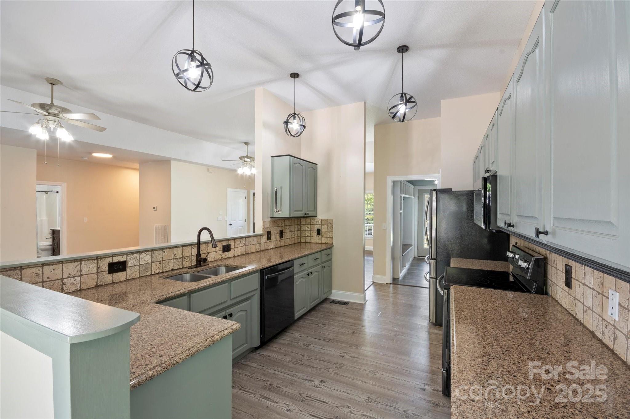 2409 Golf Course Road, Unit 14 Columbus, NC 28722 - Photo 14 of 25 a large kitchen with kitchen island a refrigerator a stove a sink dishwasher a dining table and chairs with wooden floor